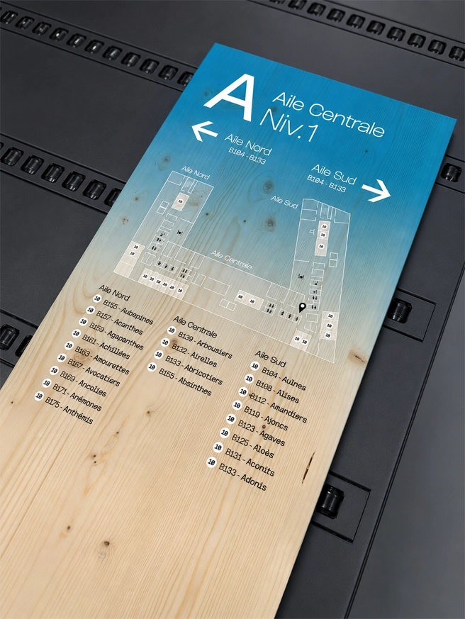 Panneau de signalétique directionnelle imprimé sur bois pour un bâtiment professionnel à Genève